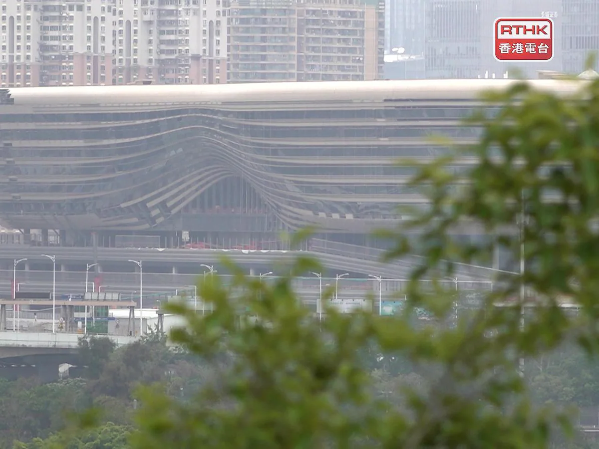 皇崗口岸聯檢大樓外觀呈流線型設計，背景為深圳市區高樓大廈。