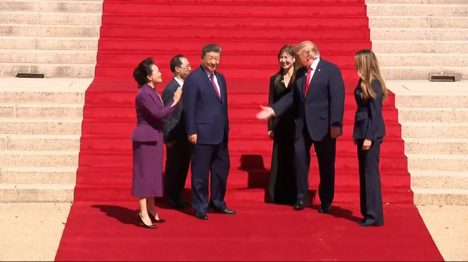 習近平與特朗普在鋪有紅地毯的階梯上準備握手。