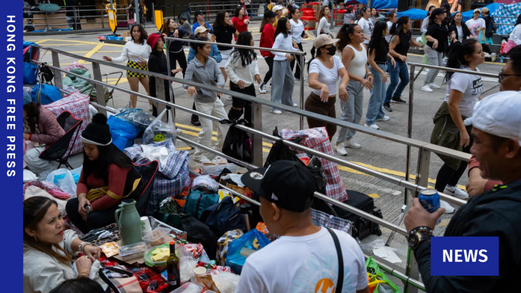 一群外籍家庭傭工在香港街頭聚集，現場放置了多個行李袋及個人物品。