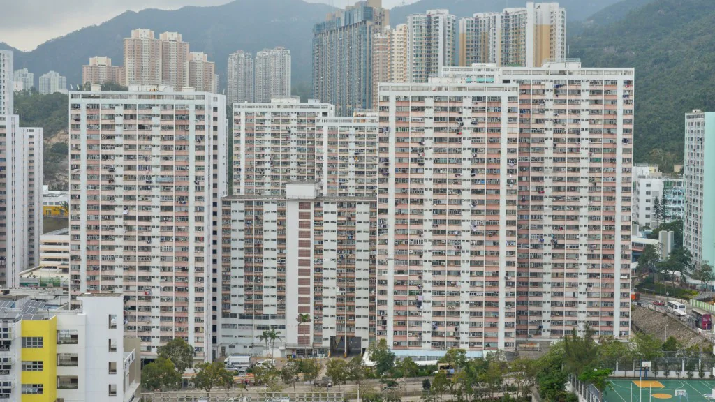 牛池灣彩雲邨的多座住宅大廈外觀，背景可見山景，畫面展示該屋邨的建築群環境。