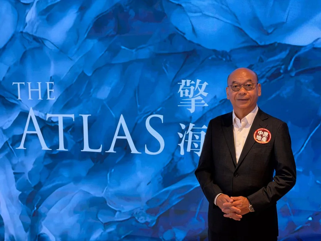 中原地產亞太區副主席兼住宅部總裁陳永傑，於印有「THE ATLAS 擎海」字樣的背景板前留影。