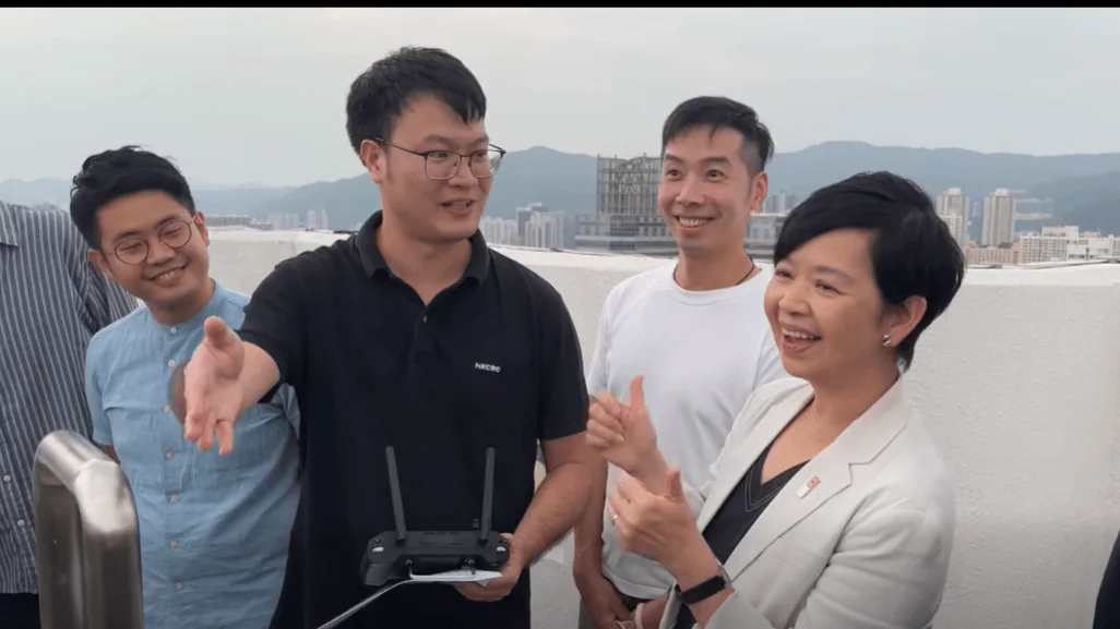 房屋局局長何永賢在麗瑤邨視察期間，與研發團隊交流並了解洗水缸機械人的操作情況。