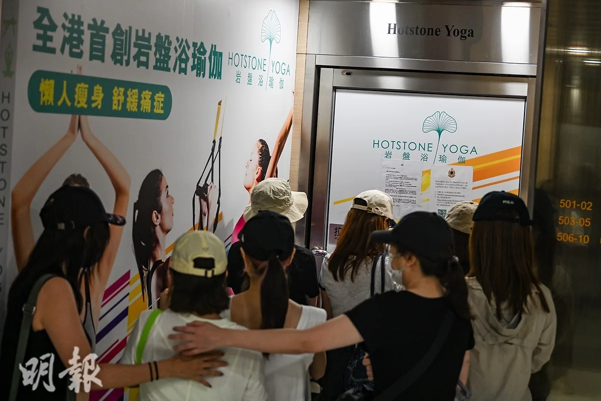 Hotstone Yoga瑜伽教室門外貼有結業告示，牆身印有品牌標誌及宣傳海報。