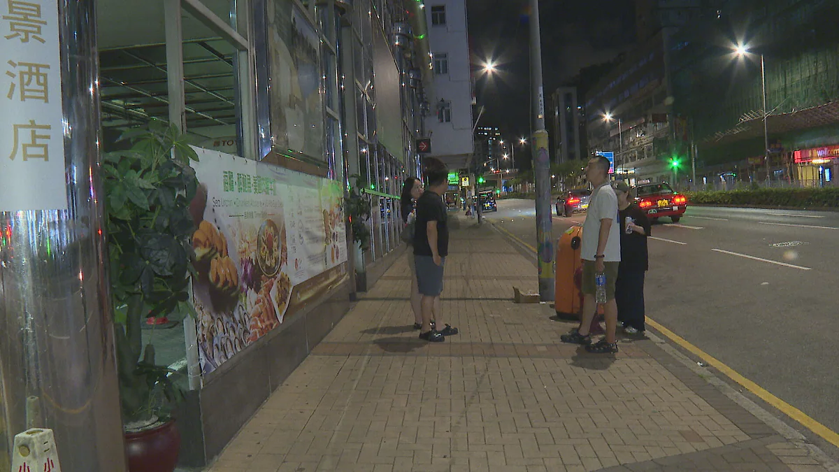 九龍維景酒店外，受停電影響的旅客在夜間攜帶行李於行人路上停留。