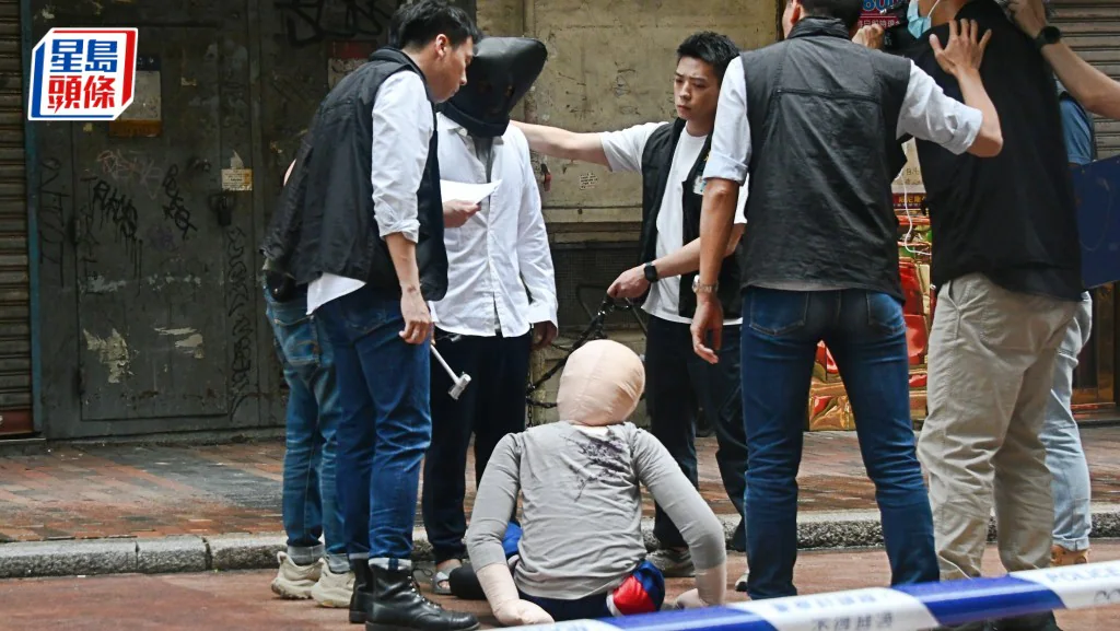 警方在油麻地庇利金街案發現場調查，多名人員圍繞涉案男子，現場拉起封鎖線。