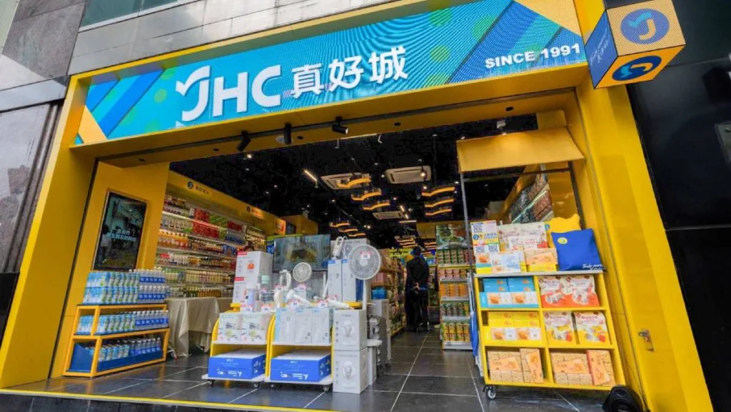 JHC真好城門店外觀，店內陳列多種家居用品及電器，門口設有貨架展示商品。