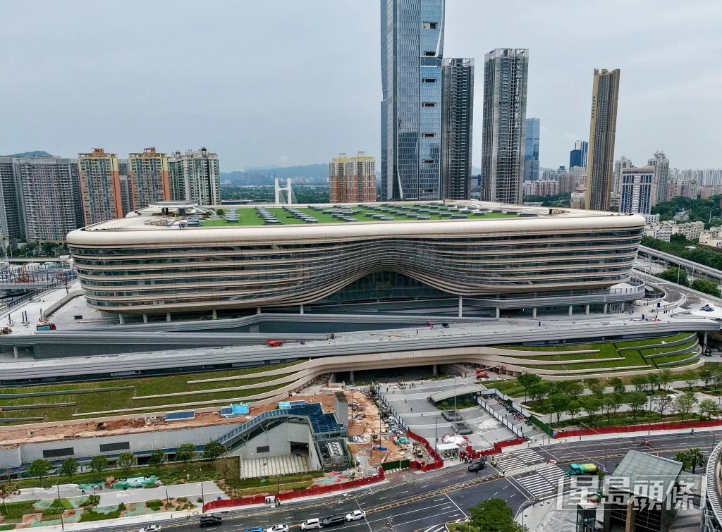 從高空俯瞰皇崗口岸大樓，建築物設有綠化天台，周邊連接多層行車天橋及道路網絡。