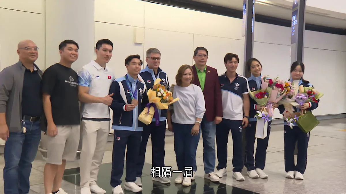 香港代表隊成員返抵香港機場，運動員與隨行人員在接機大堂合照，部分人手持鮮花並展示獎牌。