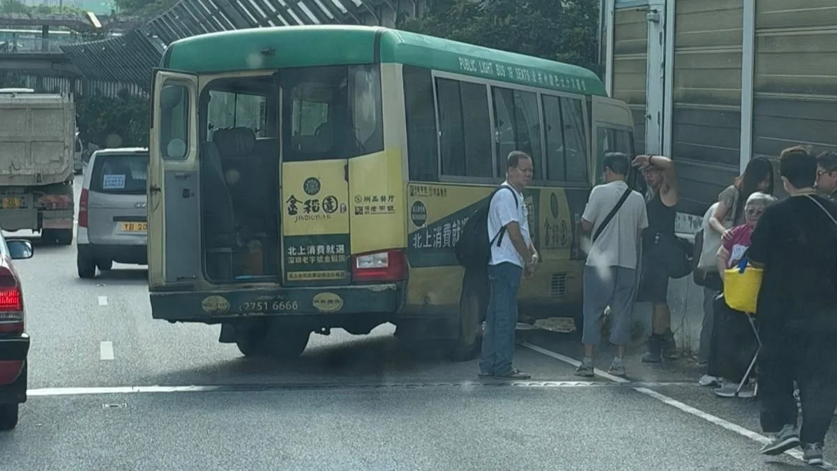 粉嶺公路發生交通意外，涉事小巴停在路邊，現場交通受阻，後方車輛緩慢行駛。