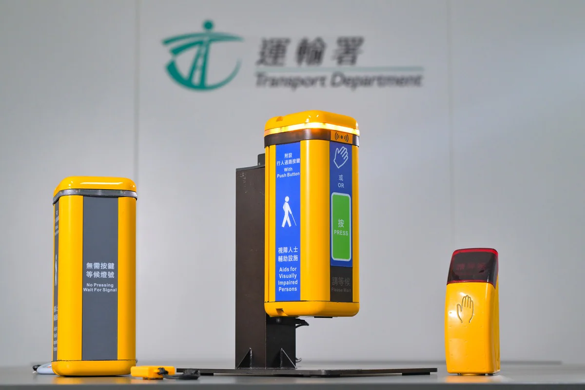 運輸署展示新一代電子行人過路發聲裝置，包括設有按鈕及感應器的型號，以及標示無需按鍵等候燈號的裝置。