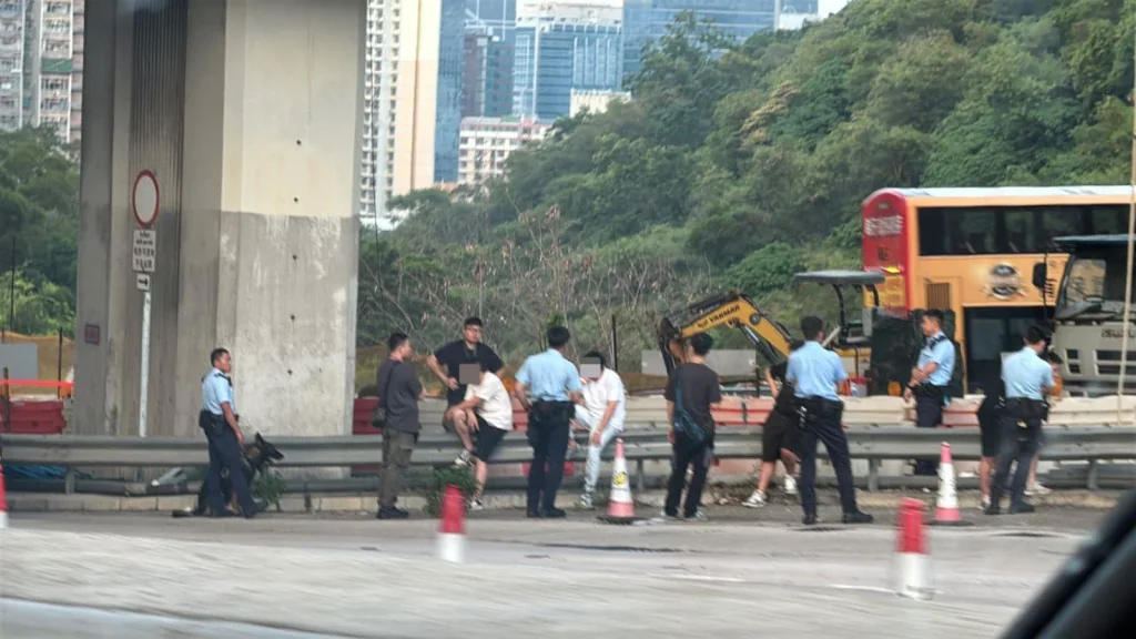 警方於將軍澳隧道公路近收費亭截停一輛懷疑涉事私家車，多名警員在場調查，現場有多名人士坐在路邊護欄旁。