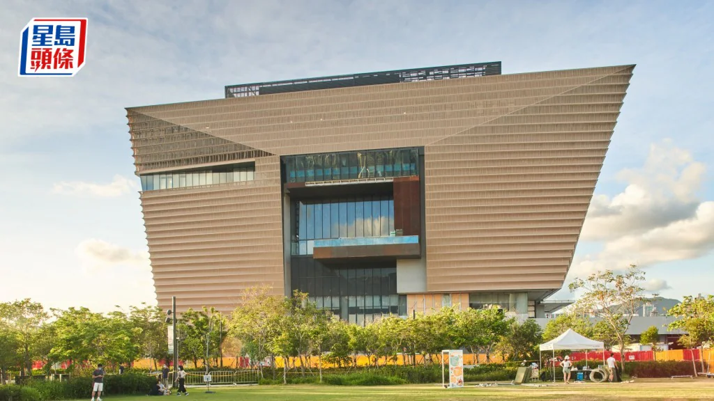 位於西九文化區的香港故宮文化博物館外觀，前方為草地及少量行人。