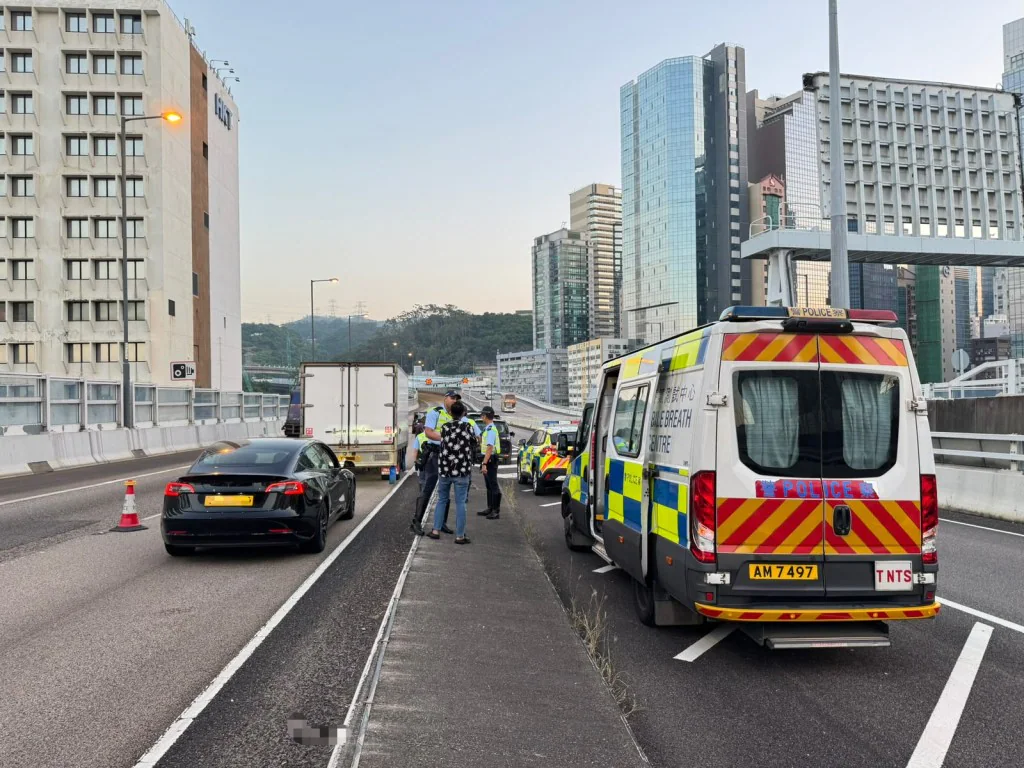 警員在道路設置路障截查私家車，現場停泊一輛寫有酒精測試中心字樣的警車。