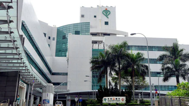 將軍澳醫院外觀，該處為事主送院搶救的地點，建築物外牆掛有醫院標誌，前方設有車道及少量植物。