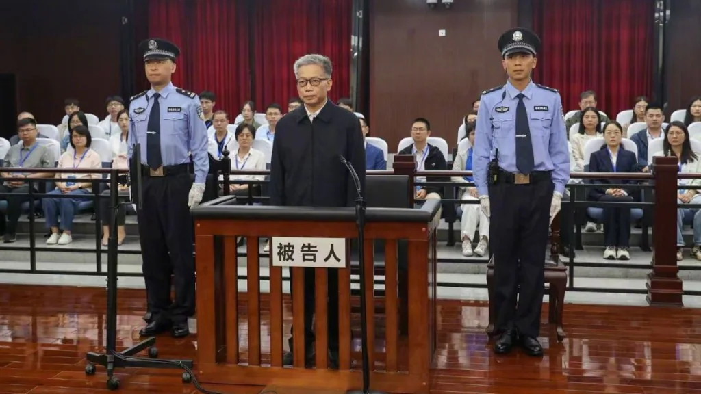 彭曉春於佛山市中級人民法院接受一審宣判，被告欄內有兩名警務人員站立看守。